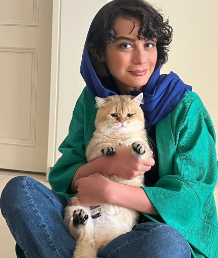 چهره‌ی اخمو و کیوت گربه‌ی مارال فرجاد در آغوشش